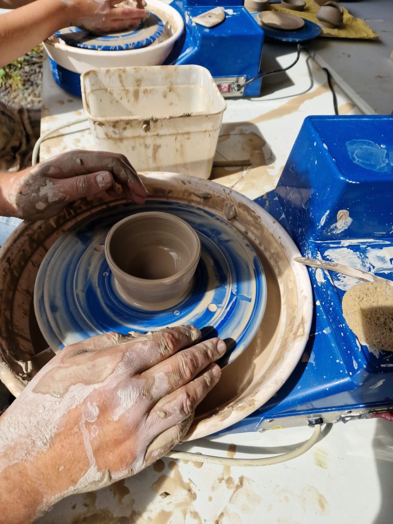 Photo showing a pot being thrown on a potters wheel.